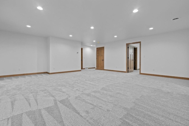 empty room with recessed lighting, baseboards, and light carpet