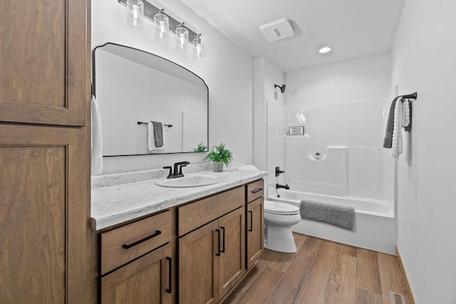 full bathroom with vanity, visible vents, shower / bathtub combination, wood finished floors, and toilet