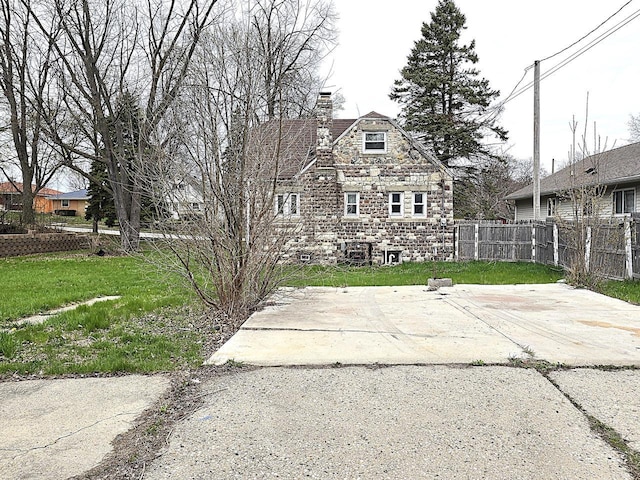 5870 N 72nd St, Milwaukee, WI 53218 - view of front of property featuring fence, a chimney, a patio area, and a front lawn