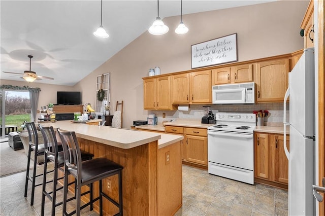 kitchen featuring a breakfast bar, white appliances, open floor plan, light countertops, and vaulted ceiling
