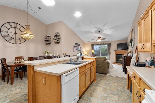 kitchen with white dishwasher, a sink, vaulted ceiling, and light countertops