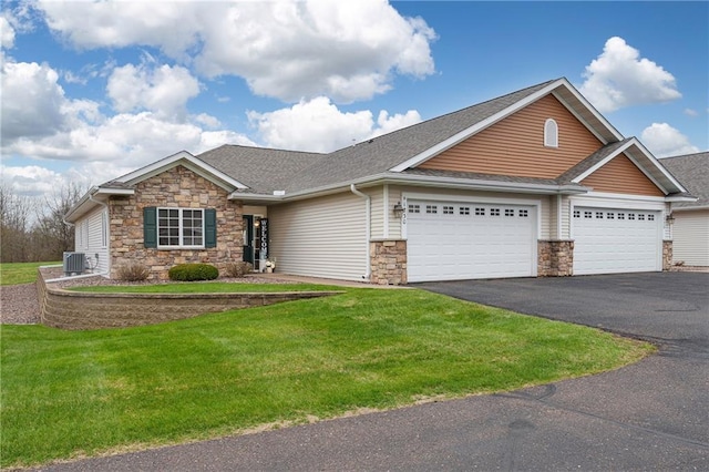 craftsman-style home featuring a garage, aphalt driveway, a front lawn, and stone siding