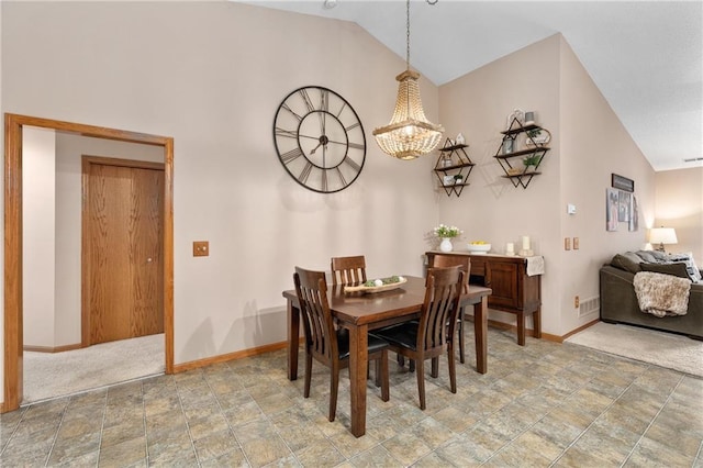dining room with baseboards, stone finish flooring, and a chandelier