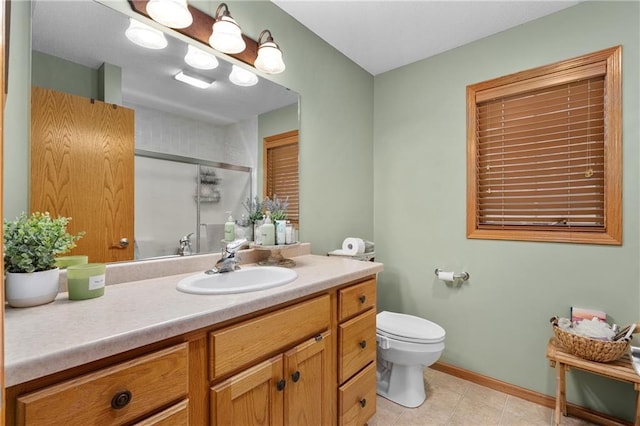 bathroom featuring vanity, toilet, tile patterned floors, baseboards, and a shower stall