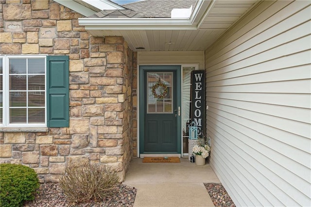 property entrance with roof with shingles and stone siding
