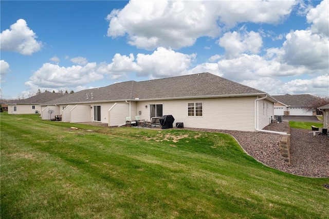 back of house featuring a lawn, a patio, and a garage