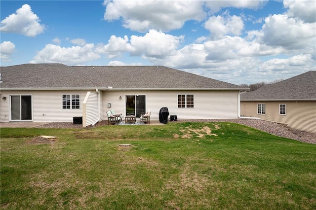rear view of property with a patio, a shingled roof, and a lawn