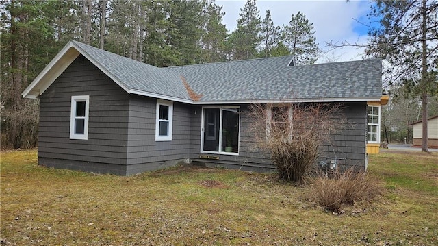 10039 State Highway 27, Hayward, WI 54843 - rear view of house featuring roof with shingles, a lawn, and crawl space