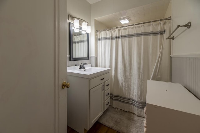 full bathroom with a shower with shower curtain, wood finished floors, and vanity