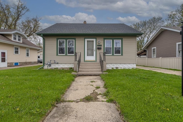 bungalow with fence, a chimney, roof with shingles, and a front lawn