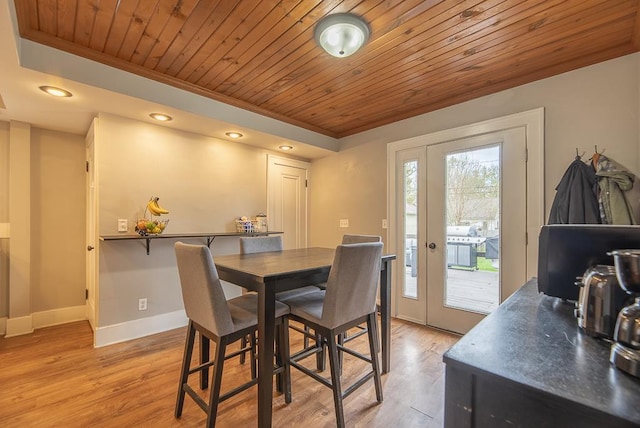dining space featuring light wood-style floors, ornamental molding, and wooden ceiling