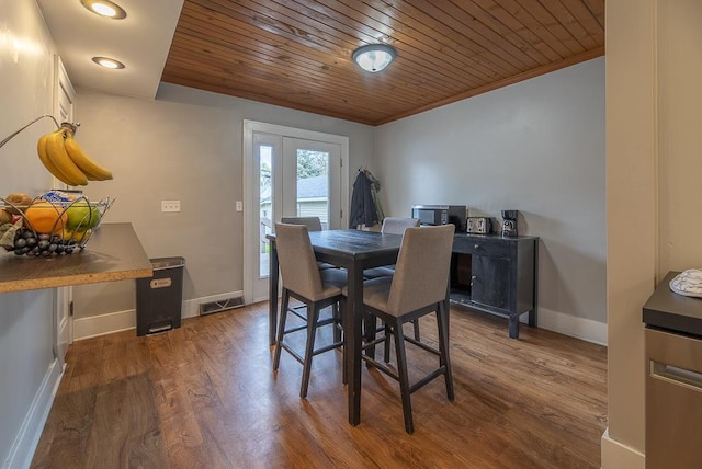 dining room featuring visible vents, crown molding, wooden ceiling, baseboards, and dark wood-type flooring