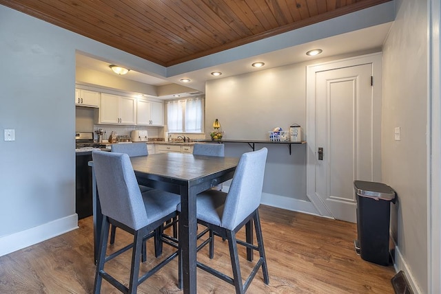 dining area featuring baseboards, ornamental molding, wood ceiling, and dark wood-type flooring