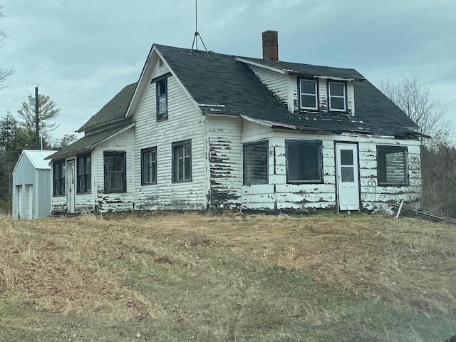 186 Abrahams Rd, Skandia, MI 49885 - exterior space with an outbuilding, a chimney, and a shingled roof