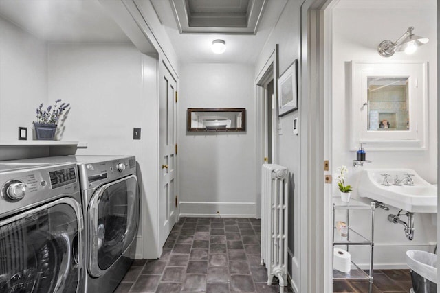 washroom featuring radiator heating unit, baseboards, laundry area, and washing machine and dryer