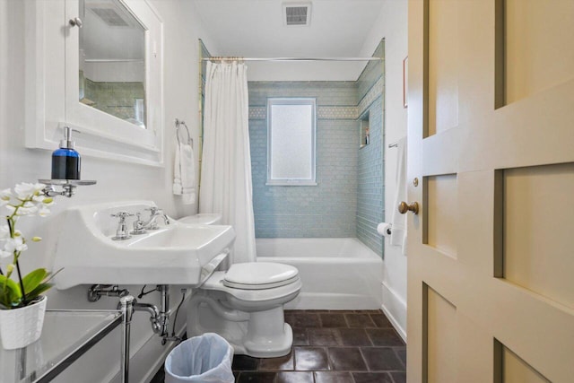 bathroom featuring shower / bathtub combination with curtain, stone finish flooring, toilet, and visible vents