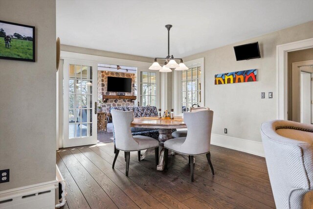 dining area featuring an inviting chandelier, baseboards, plenty of natural light, and dark wood-style flooring