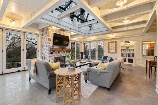 living room with a fireplace, a wealth of natural light, a skylight, and beamed ceiling