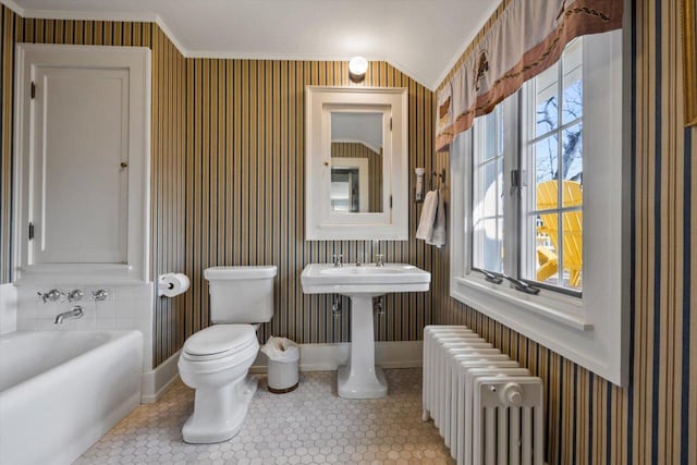 bathroom featuring toilet, ornamental molding, radiator heating unit, and a wealth of natural light