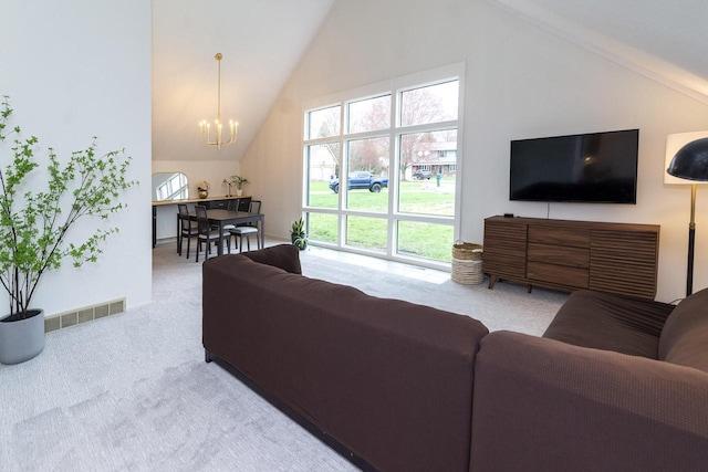 carpeted living area with high vaulted ceiling, a notable chandelier, and visible vents