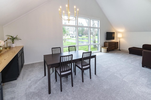 dining area with baseboards, a notable chandelier, vaulted ceiling, and light carpet