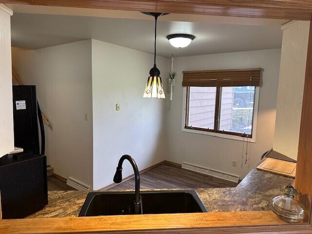 kitchen with baseboards, refrigerator, dark wood finished floors, and a sink