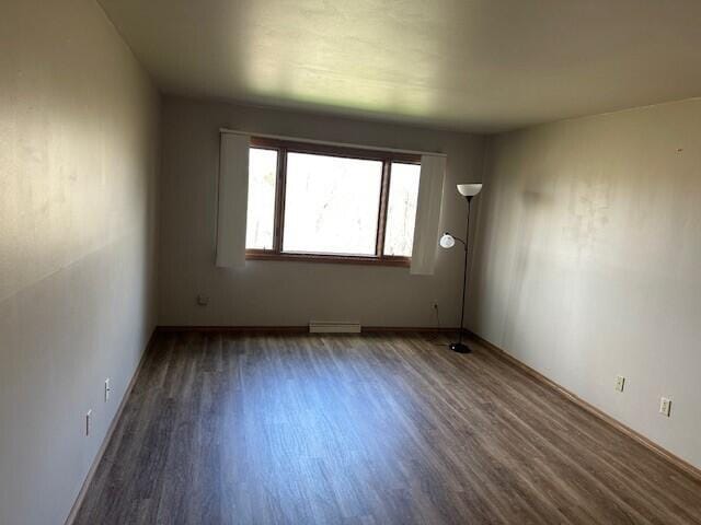 empty room featuring visible vents, baseboards, and wood finished floors