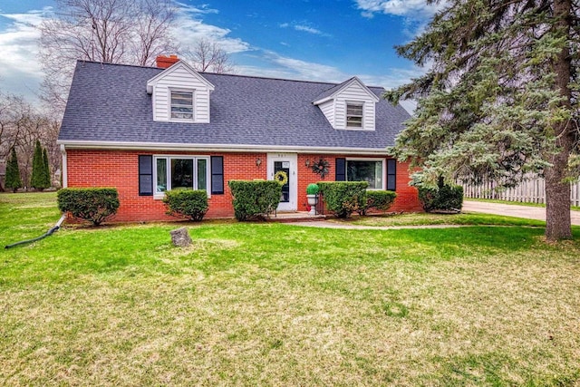 901 E Grant St, Appleton, WI 54911 - cape cod house with brick siding, a chimney, a front yard, and roof with shingles