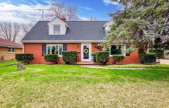 901 E Grant St, Appleton, WI 54911 - cape cod-style house featuring roof with shingles, a chimney, a front lawn, and brick siding