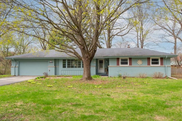 view of front of house with brick siding, aphalt driveway, a front yard, and a garage