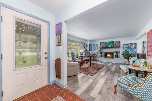 foyer with a glass covered fireplace and wood finished floors