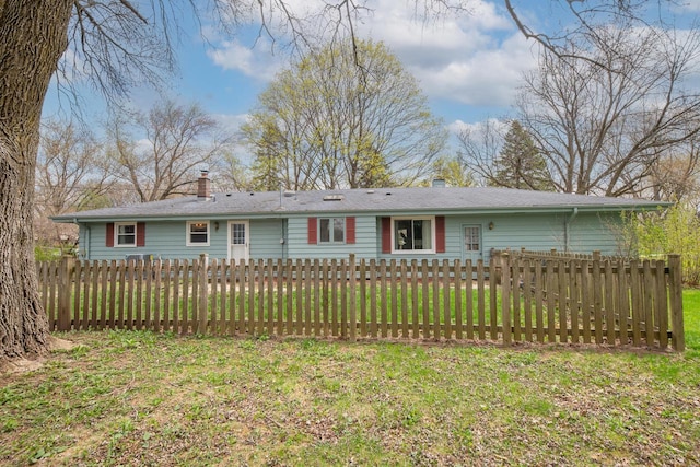 ranch-style house with fence, a chimney, and a front lawn