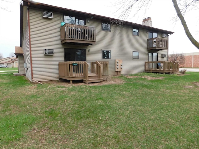 rear view of property with a lawn, a chimney, and a balcony