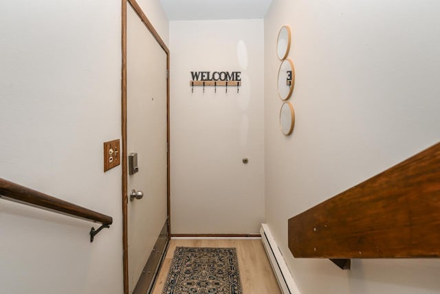 entryway featuring a baseboard heating unit and wood finished floors