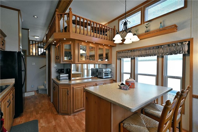 kitchen featuring freestanding refrigerator, an inviting chandelier, plenty of natural light, and a kitchen bar