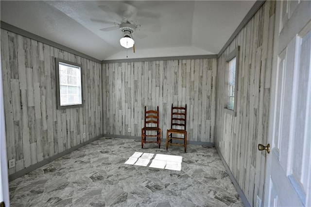 unfurnished room with baseboards, ceiling fan, and vaulted ceiling