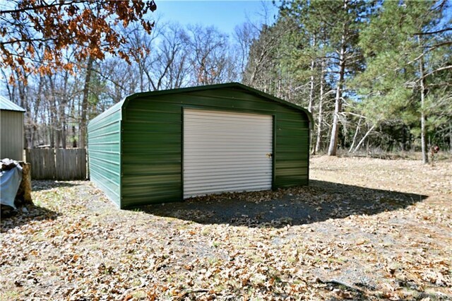 view of outdoor structure featuring fence and an outbuilding
