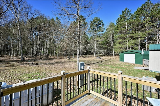 wooden deck with a storage shed, a detached garage, and an outdoor structure