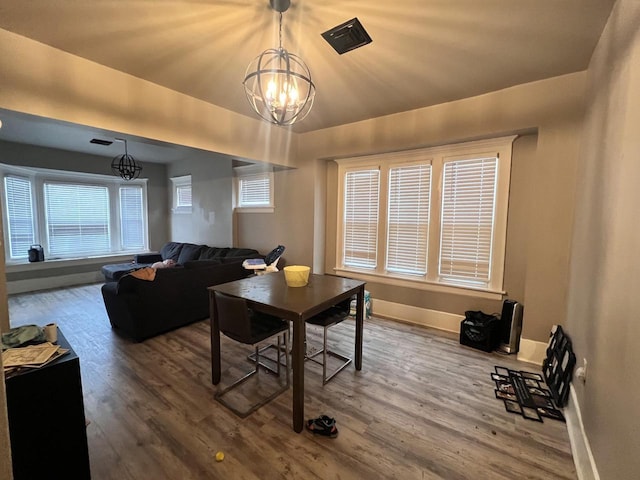 dining room with baseboards, a notable chandelier, plenty of natural light, and wood finished floors