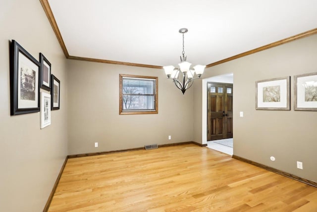unfurnished dining area featuring light wood-style floors, ornamental molding, a chandelier, and visible vents
