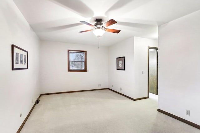 empty room featuring baseboards, a ceiling fan, and light carpet