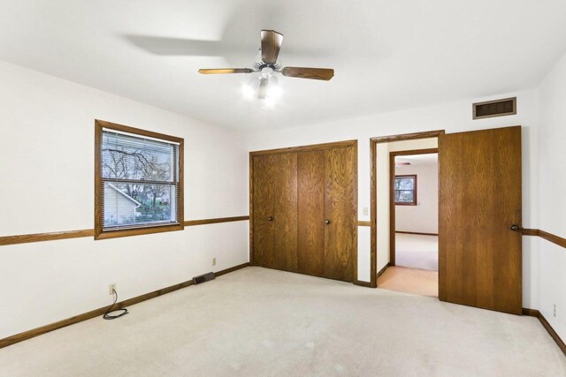 unfurnished bedroom with carpet floors, baseboards, visible vents, and a closet