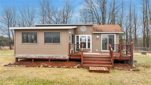 rear view of house featuring a yard, fence, and a deck