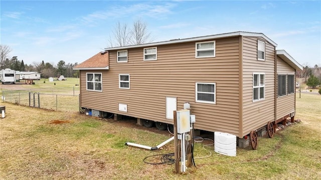 back of property with fence and a lawn