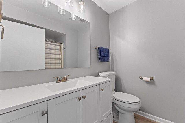 full bath with vanity, wood finished floors, toilet, baseboards, and a shower with shower curtain