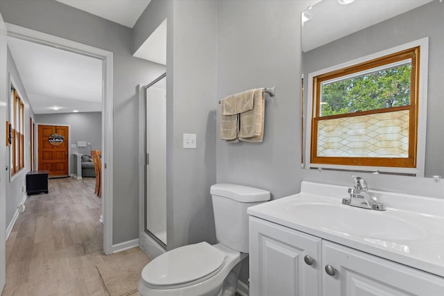 full bath featuring vanity, toilet, baseboards, wood finished floors, and a stall shower