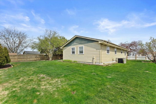 view of side of property with a lawn and a fenced backyard
