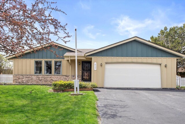 single story home featuring board and batten siding, driveway, a front yard, a garage, and fence