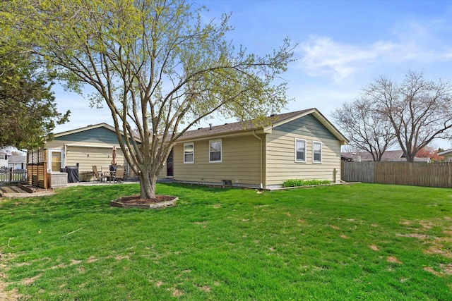 back of house featuring fence, a patio, and a lawn