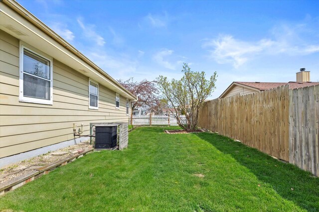 view of yard with central AC unit and a fenced backyard